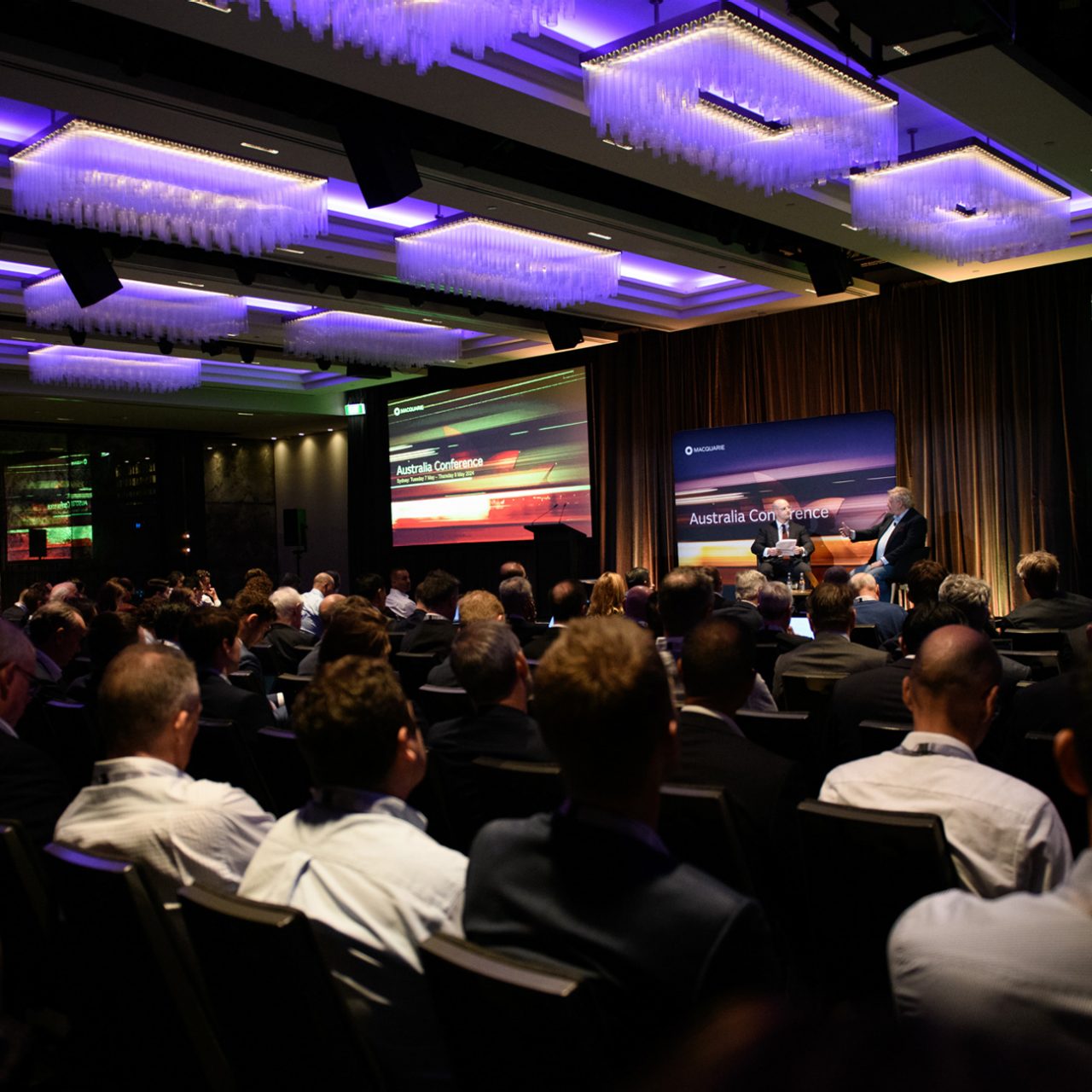 Crowd of attendees watching a presentation at the Australia Conference 2024