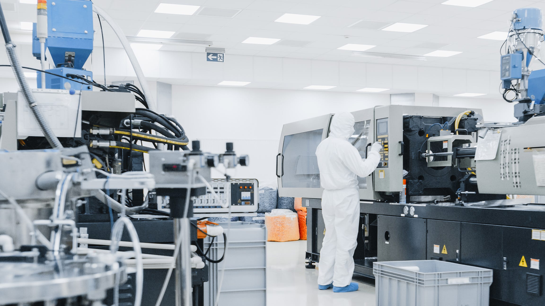 lab worker in full body ppe suit operating lab equipment