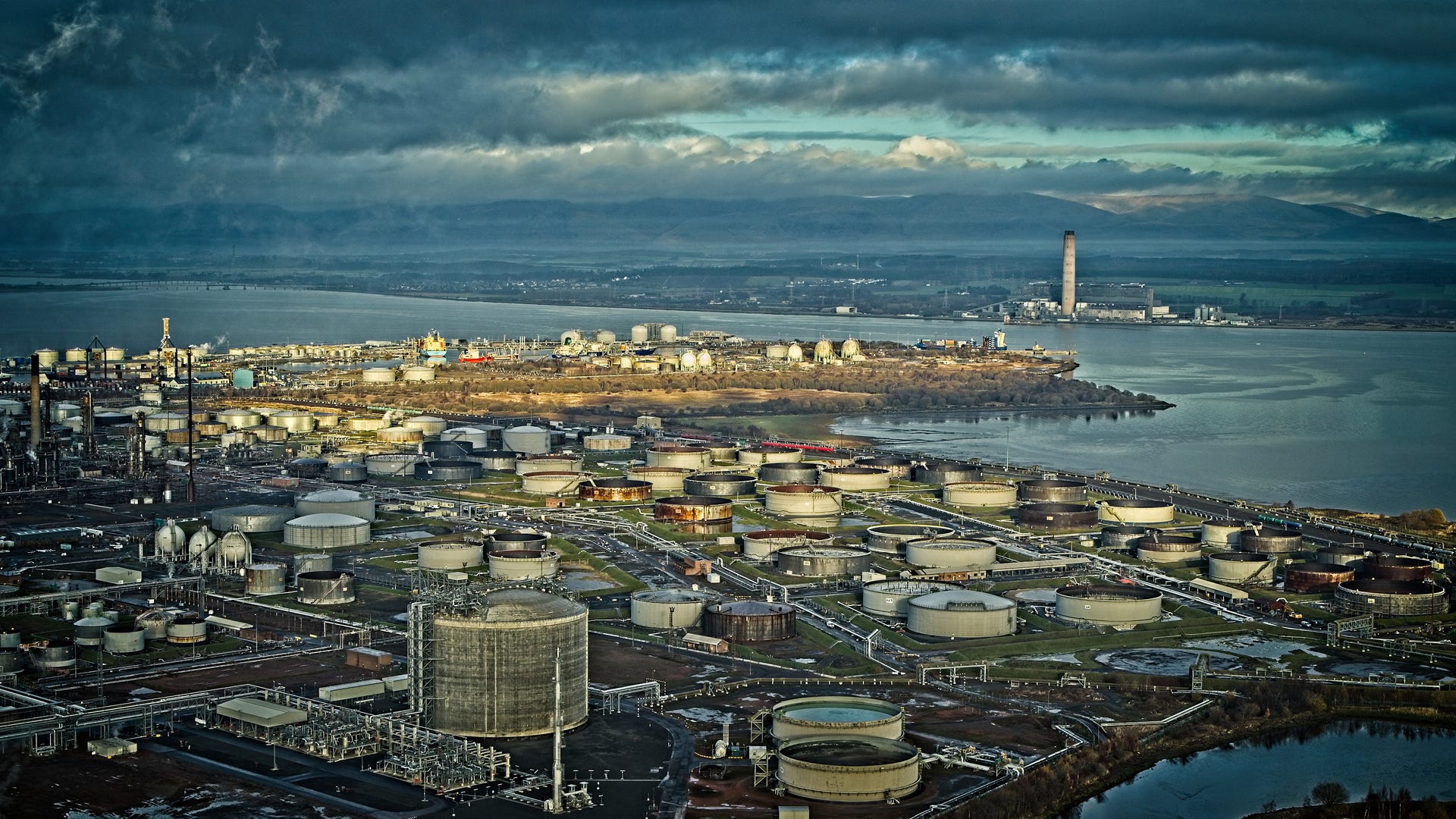 industrial complex by the water with many cylindrical structures