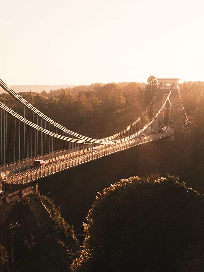 wider angle of cars driving over a bridge with columns at both ends