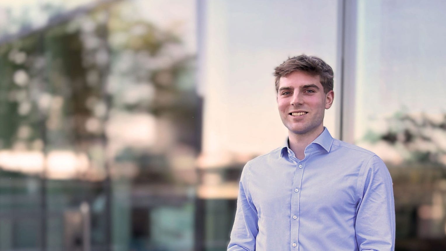 Liam O'Kane smiling in an office lobby
