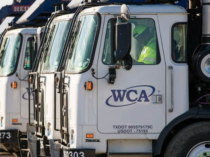 three wca trucks lined up with worker in hi-vis sitting in one