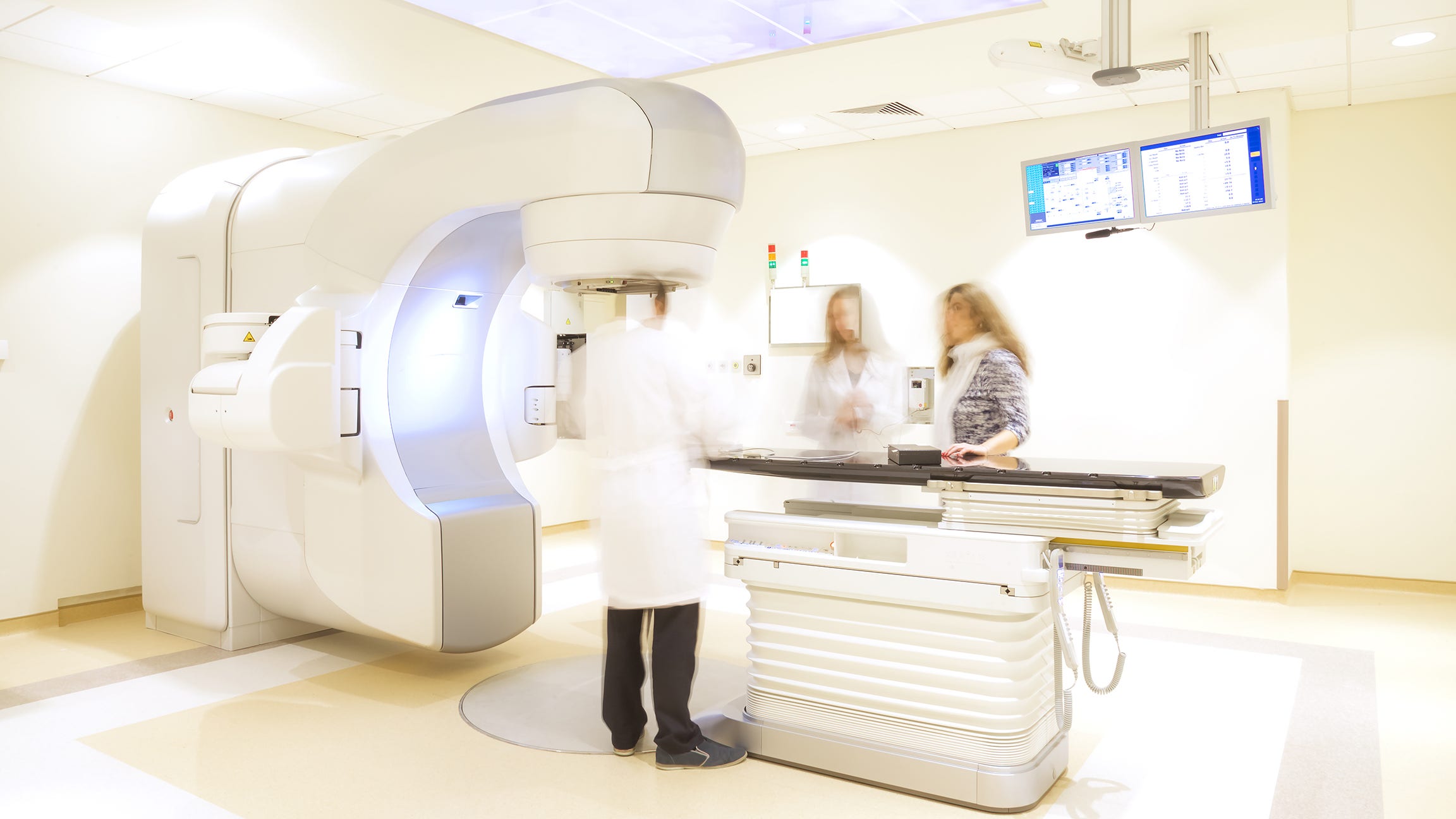 three medical professionals standing around healthcare equipment