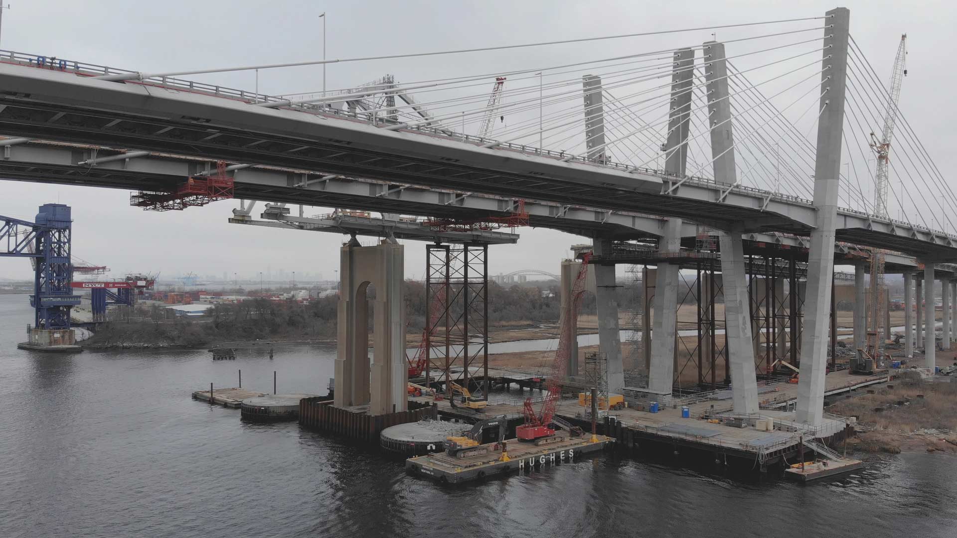 wider high angle of bridges under construction with cranes