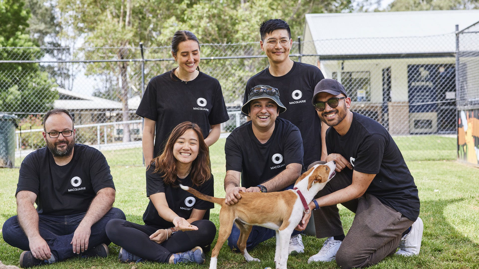 Macquarie employees at a Macquarie Foundation event sitting with a dog