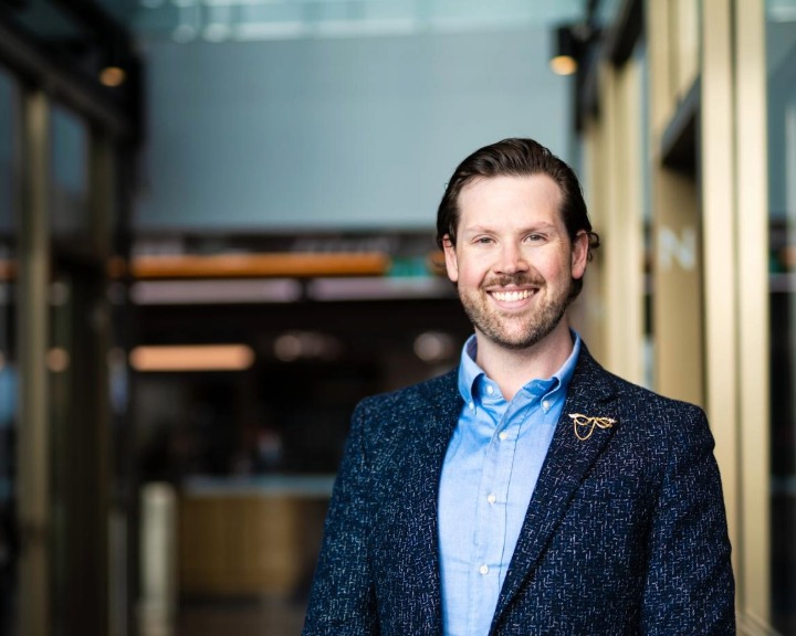 Liam O'Kane smiling in an office lobby