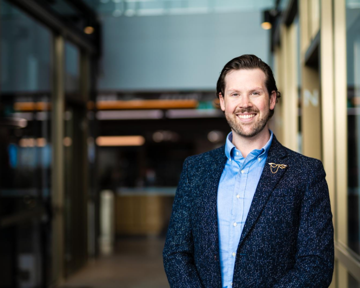 Liam O'Kane smiling in an office lobby