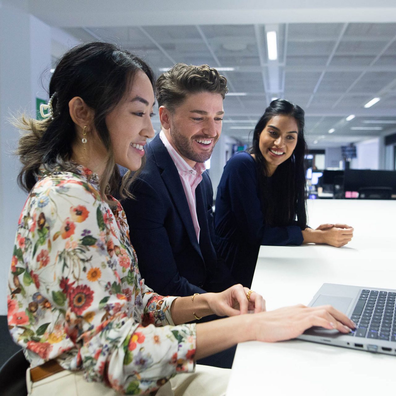 A group of business people looking at a computer, discussing a topic