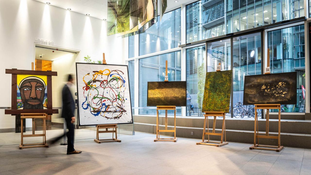 A man browsing through a pop-up art exhibition by acclaimed artist Hanifa Queen at Macquarie's London office