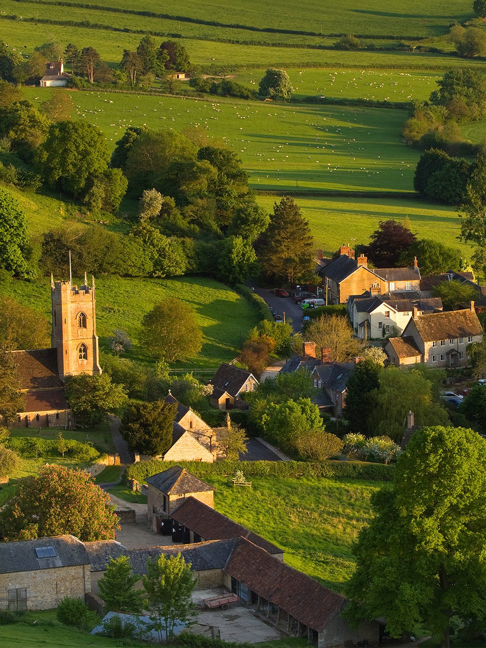 high angle of rural town amongst lush green landscape