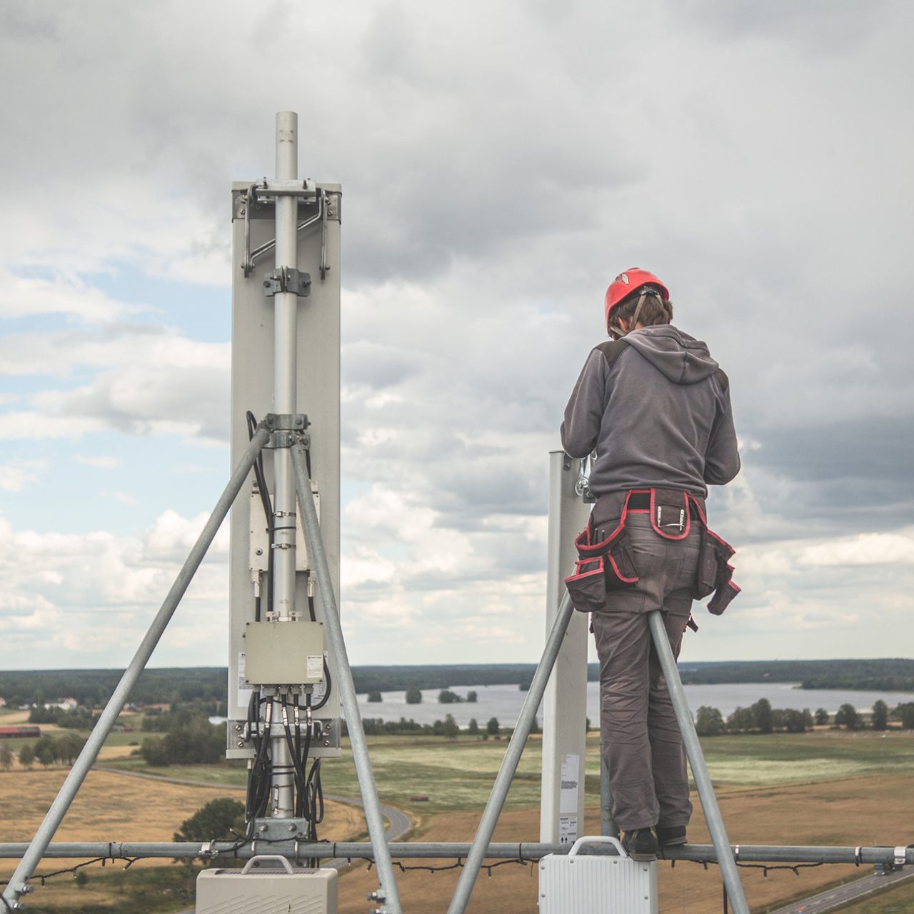 Telecommunication engineer installing new antenna on top of mobile base station