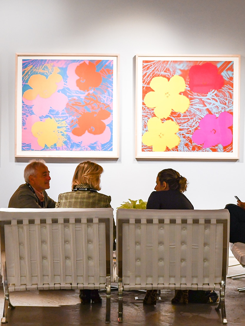 Floral artwork on wall with group discussion