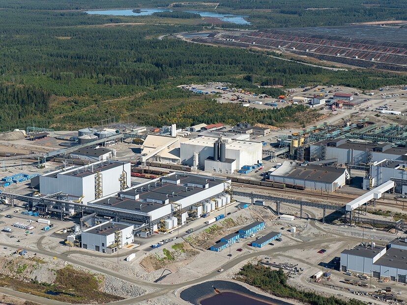 Aerial shot of an industrial warehouse surrounded by a local forest 