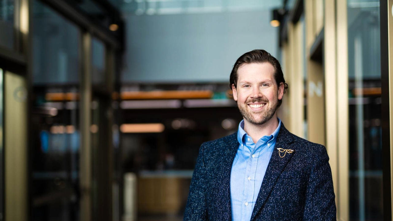 Liam O'Kane smiling in an office lobby