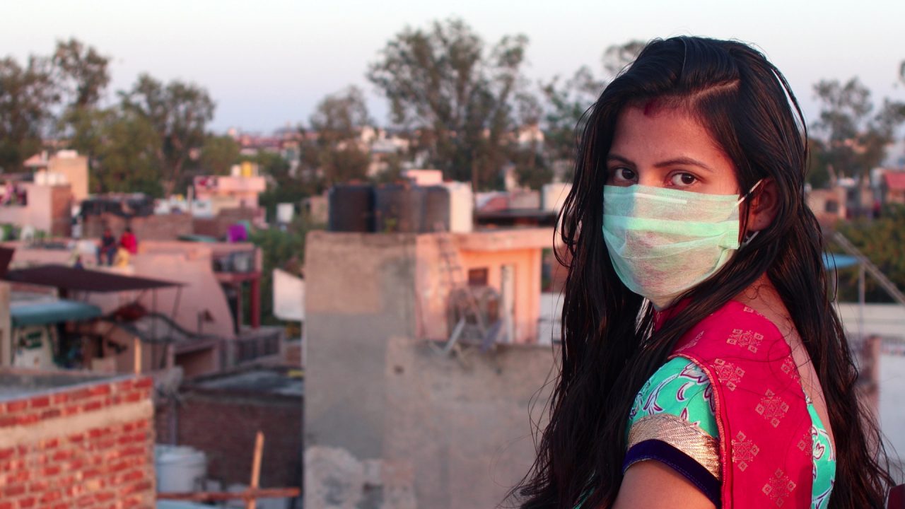 A lady in a surgical mask looking back at the camera
