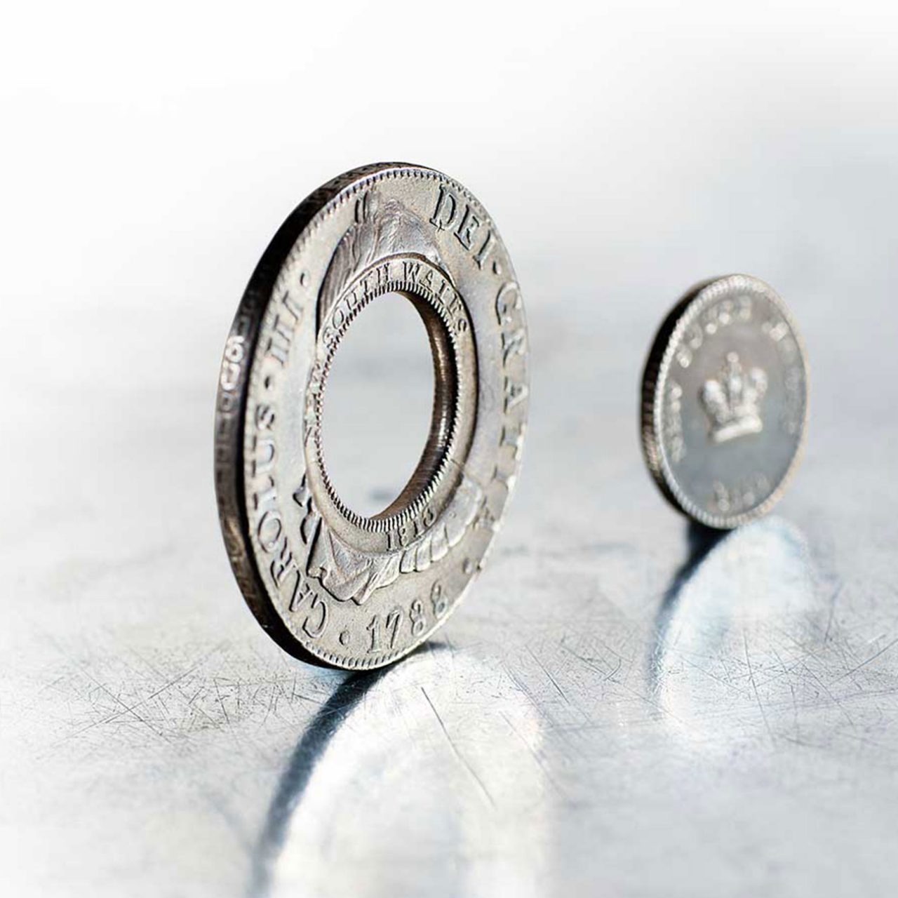 The holey dollar, a flat, doughnut-shaped silver coin, and small coin known as a 'dump'