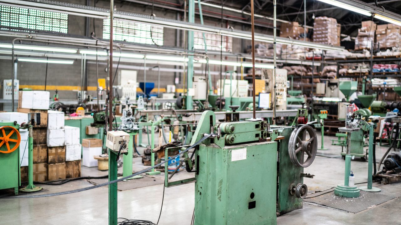 factory interior with belts, wheels and boxes in the background