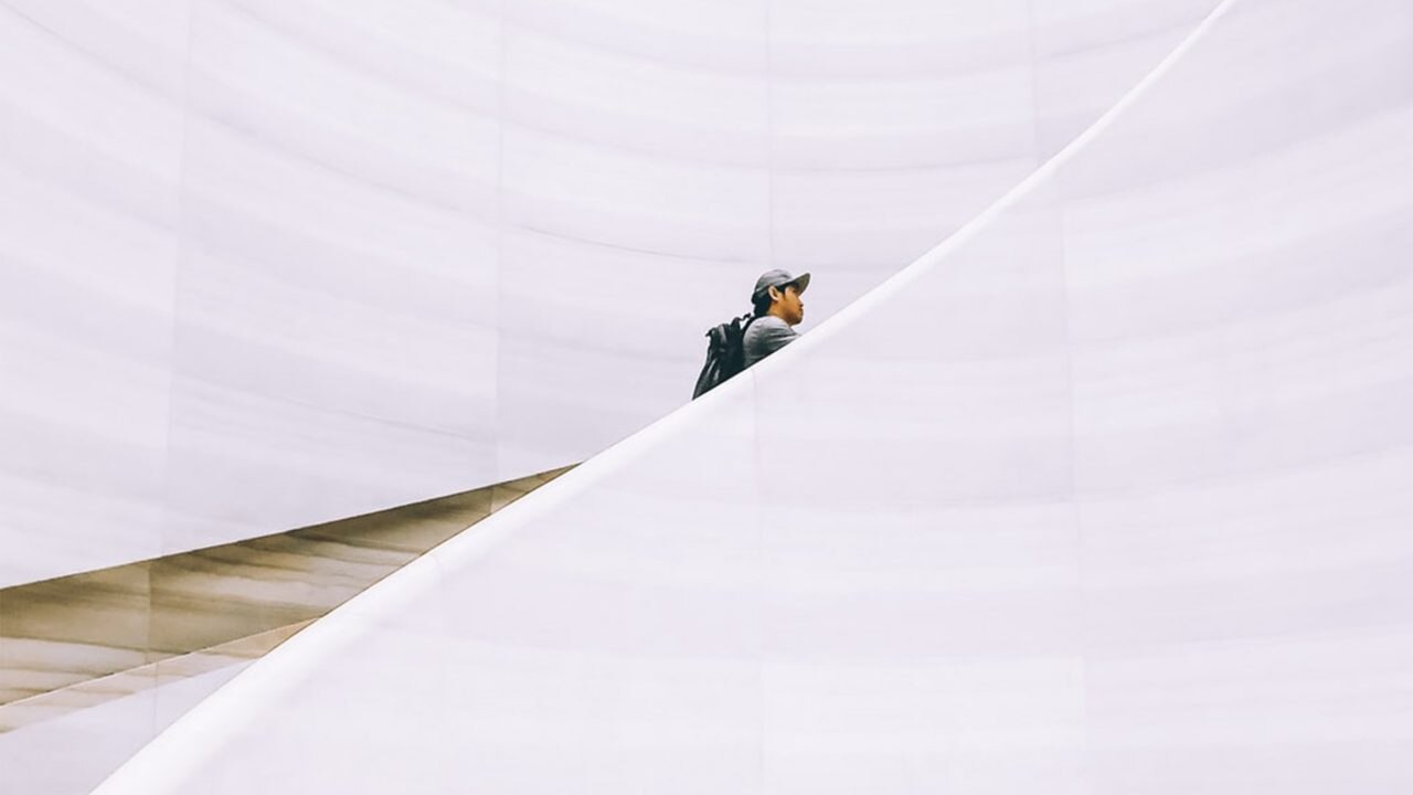 Man walking up white building