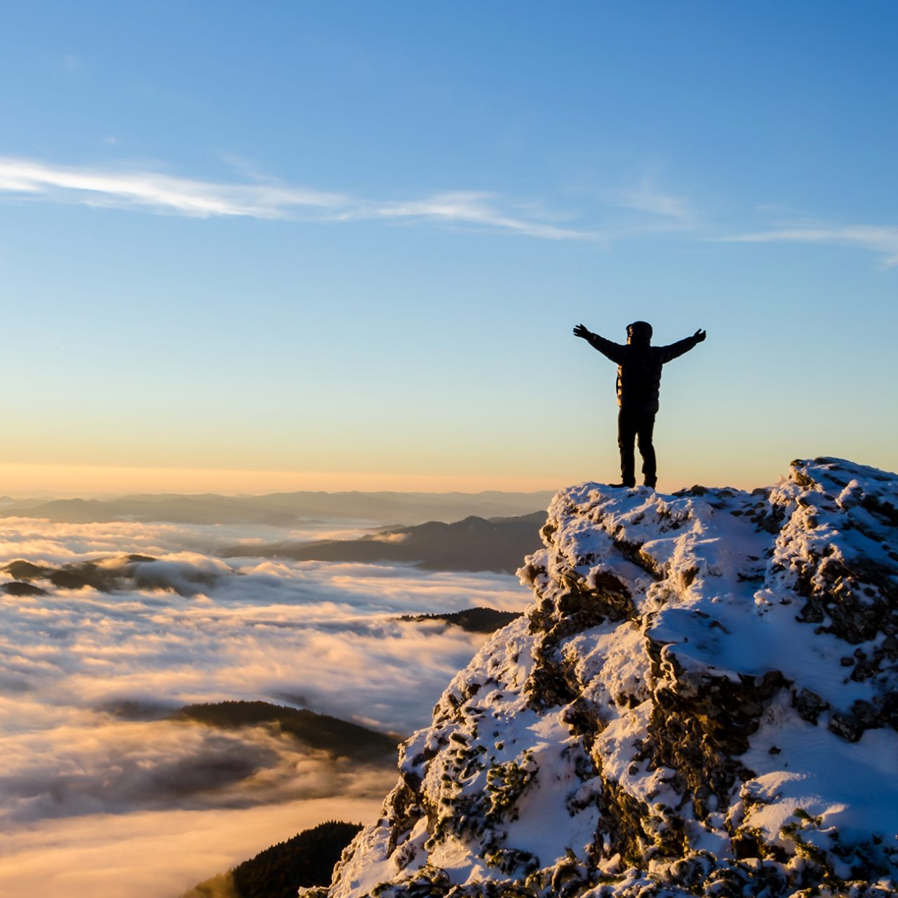 Hiker celebrating success on top of a mountain