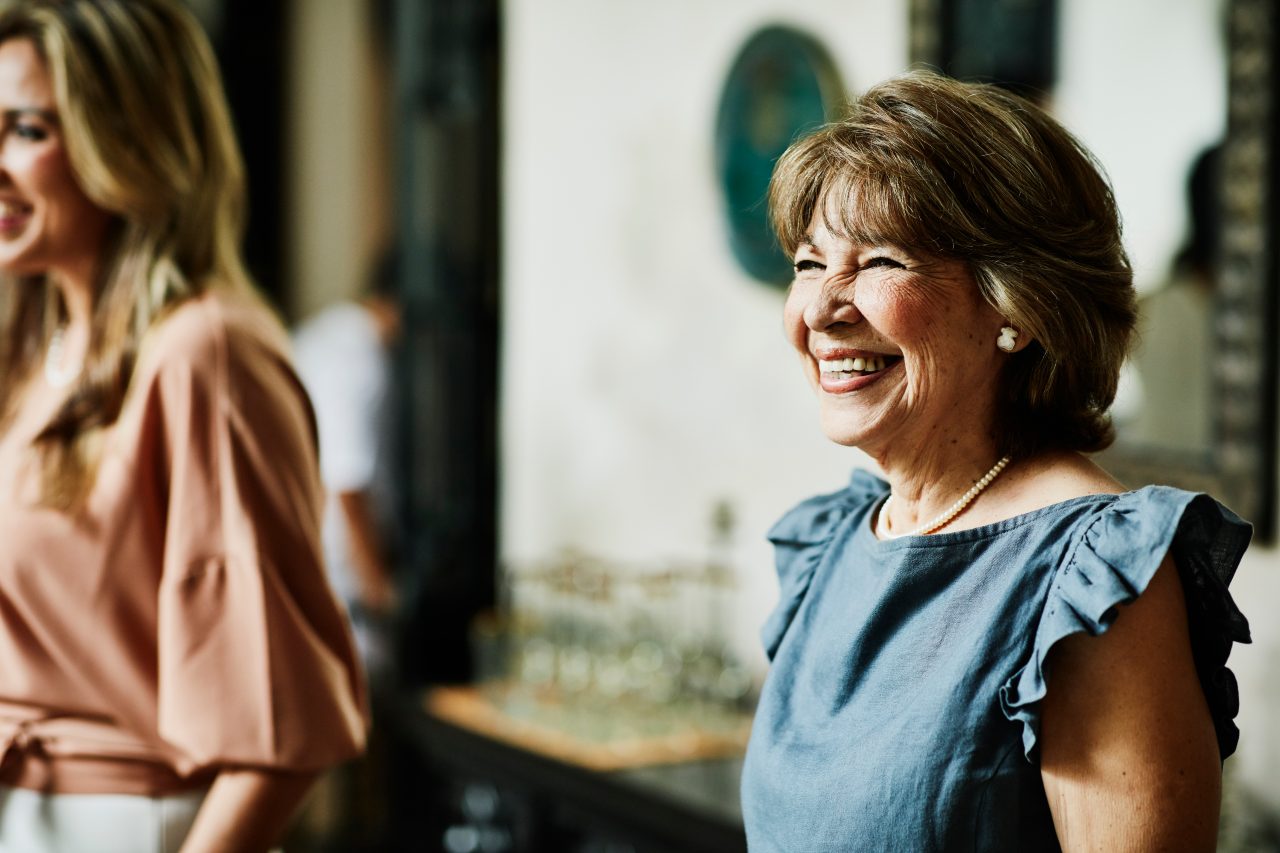 Smiling grandmother hanging out with family members before dinner party