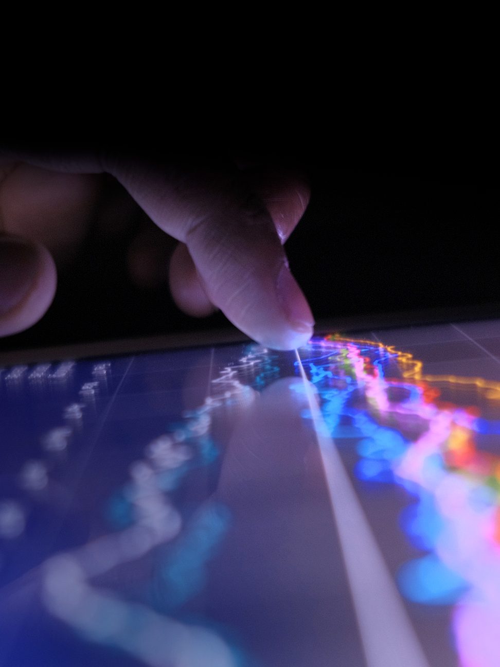 Close up of man hand with digital tablet analyzing stock market graph at night